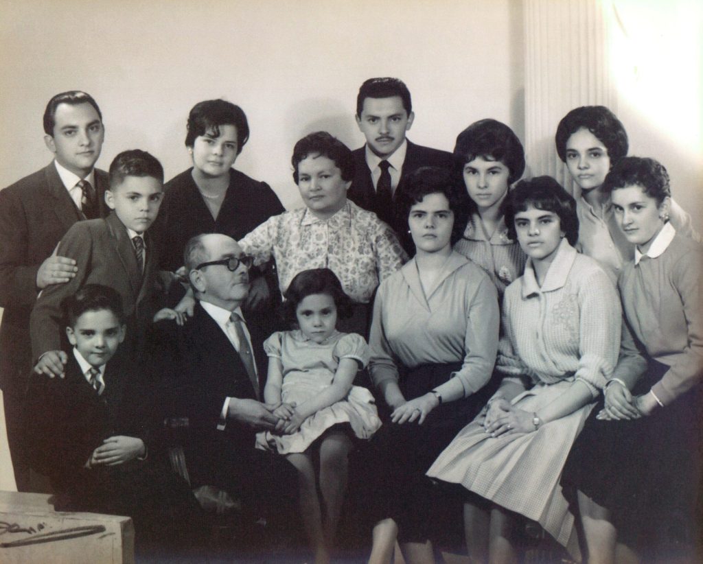Old family photo with men in suits and ties, women in nice dresses