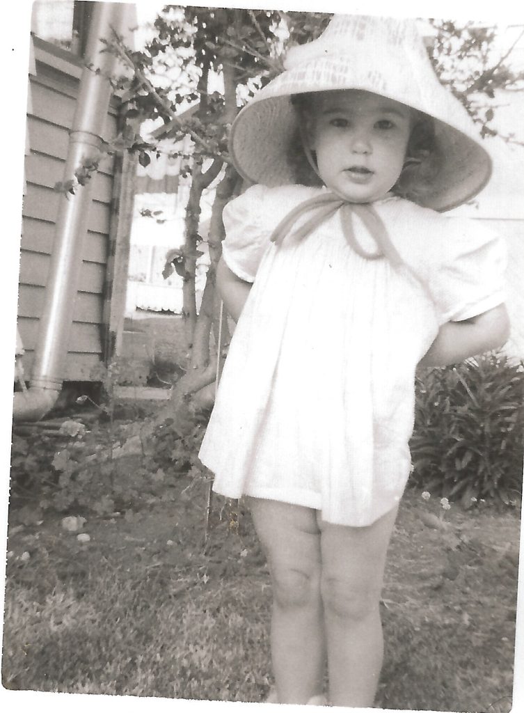 Toddler girl in wide brim hat.