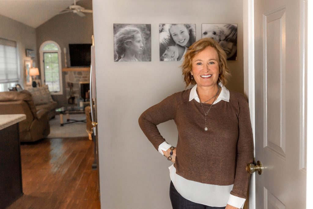 Marianna in front of wall photos