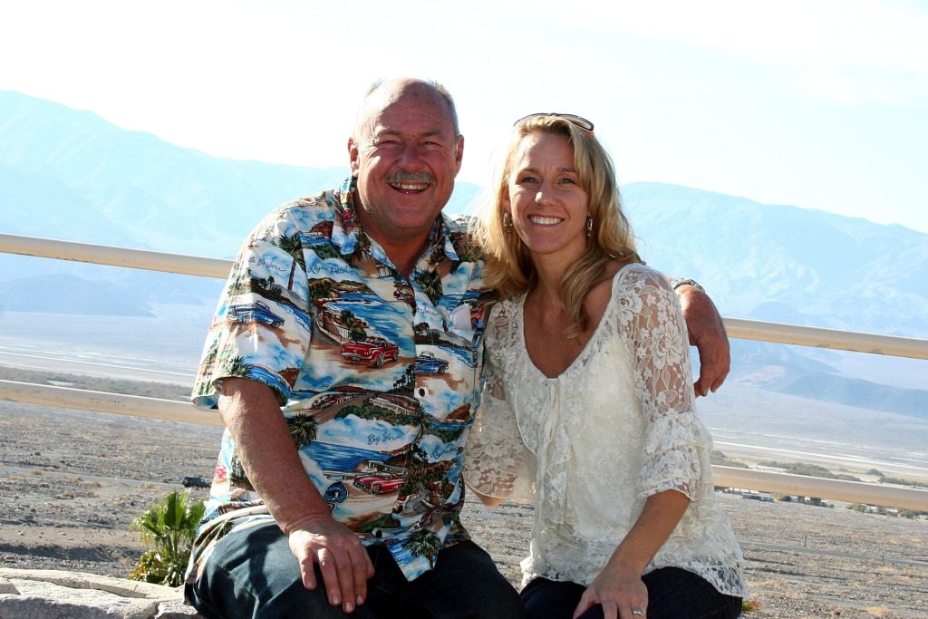 Father and grown daughter on beach