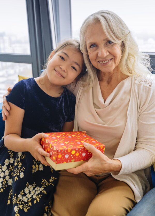 Young girl giving present to older woman