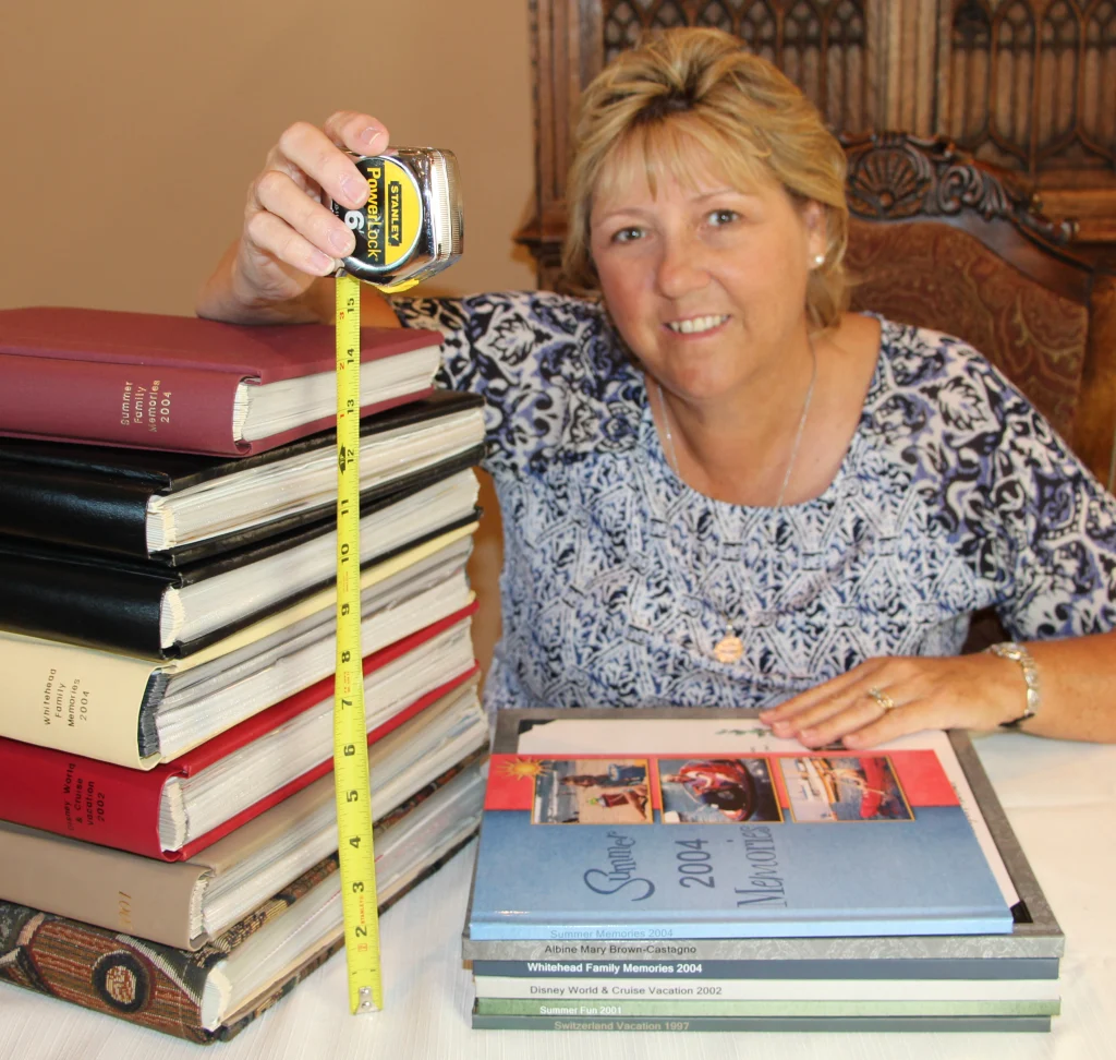 Woman with measuring tape by stack of photo albums