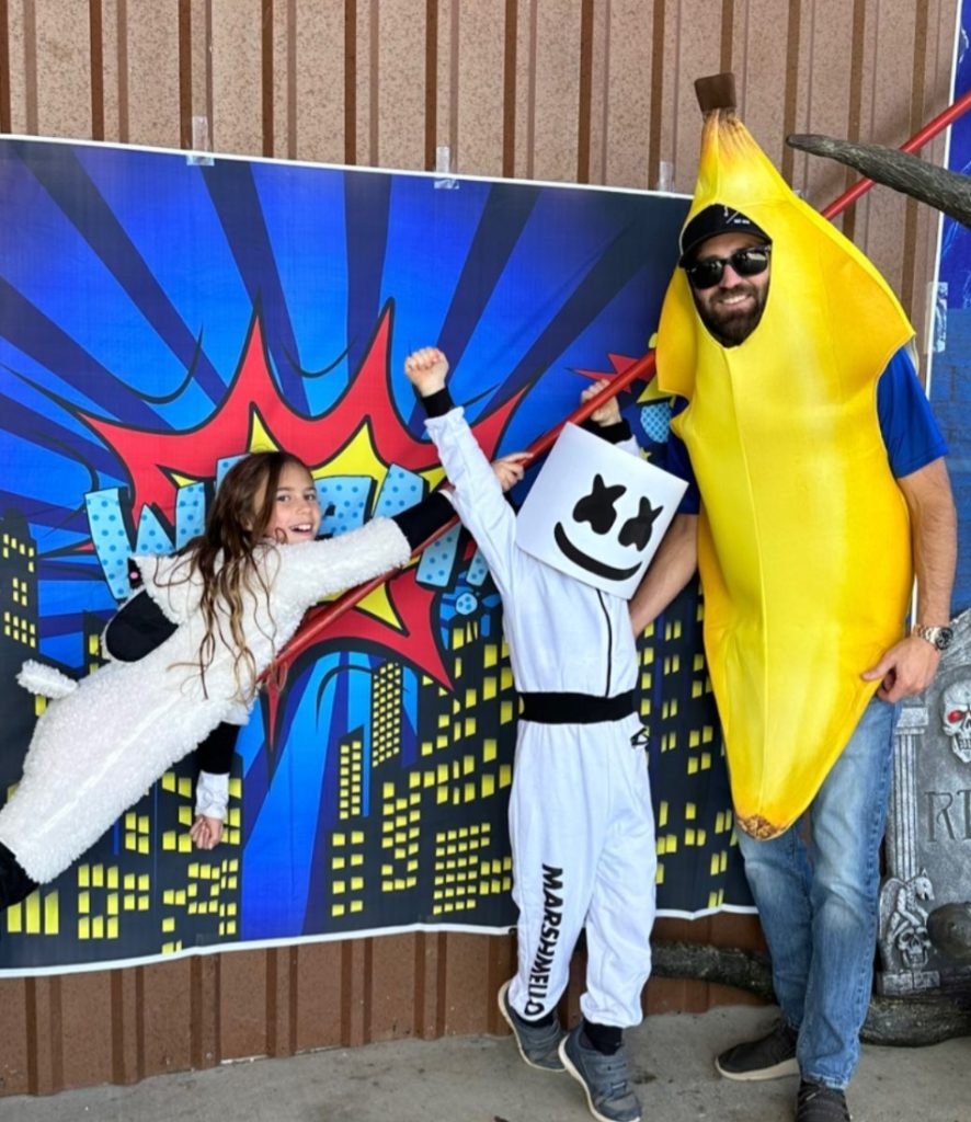 Man and kids in Halloween costumes
